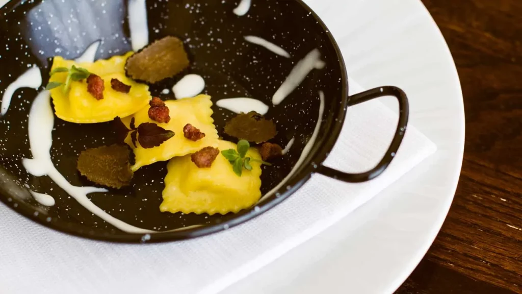 Ravioli con salsiccia e salsa di Parmigiano Reggiano DOP 30 mesi in un tegamino